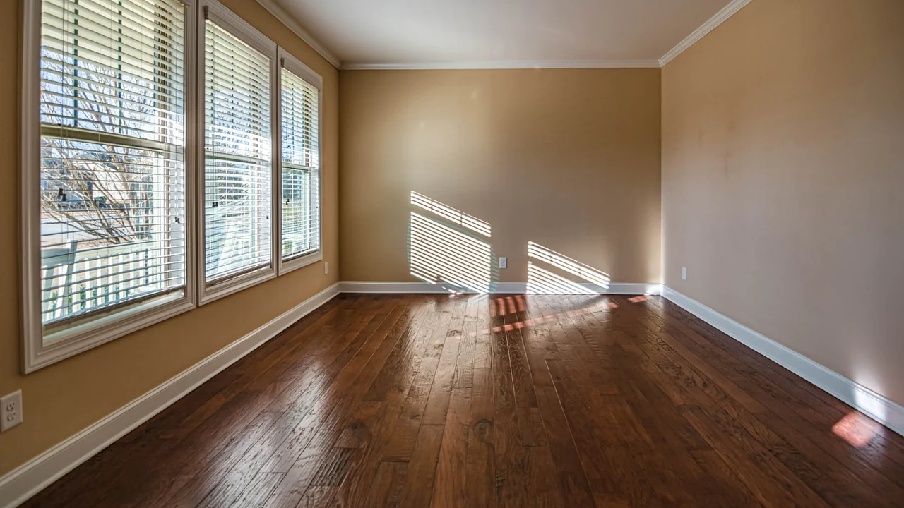 An empty room in Hernando with new dark hardwood flooring laid straight to the walls